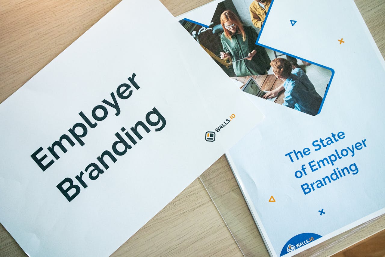 Flat lay of employer branding materials on an office table, showcasing marketing and design.
