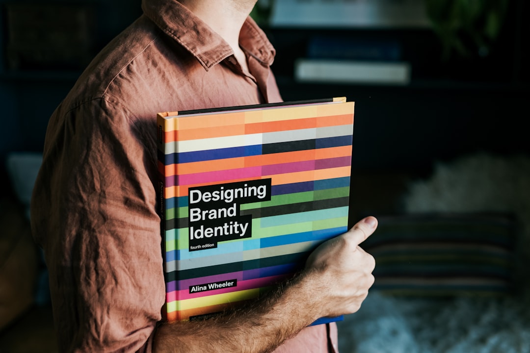 a-man-holding-a-book-that-says-designing-brand-identity-wkw5nxoxizq